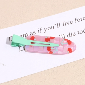 Detail of pink jelly cherry hair clip with mint green matte metal duckbill clip design