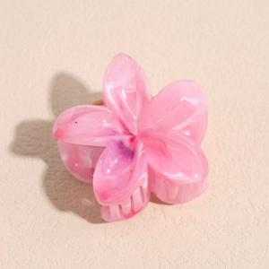 Dettaglio della pinza per capelli a fiore rosa con trama marmorizzata e molla in metallo