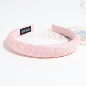 Dettaglio del tessuto jacquard floreale rosa e dell'etichetta fatta a mano sul cerchietto