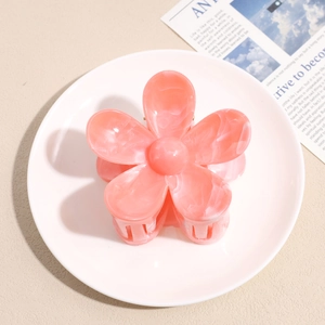 Detail of pink marble floral hair claw clip on ceramic plate with elegant design