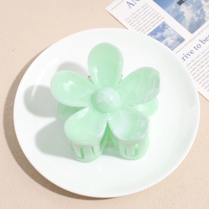 Detail showing mint green floral hair claw clip with marble texture for hairstyles