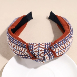 Detail shot of bohemian braided headband with geometric texture on a ceramic tray
