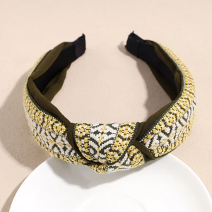 Detail of green woven wide headband featuring ethnic texture and stylish center knot