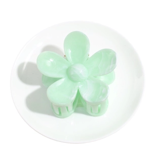 Large pale green marble pattern flower hair claw clip on a white decorative plate