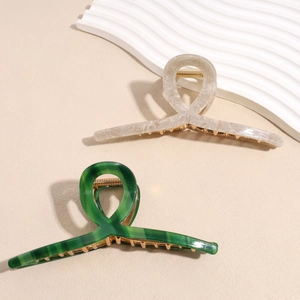Detailed macro view of 13cm acetate hair claws with marble texture and golden springs