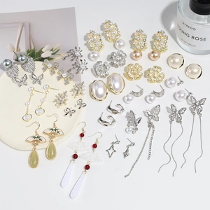Vista plana de pendientes de perlas en plata 925 con borlas de mariposa y motivos florales