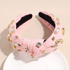 Détail du serre-tête baroque rose avec strass brillants et design à nœud élégant