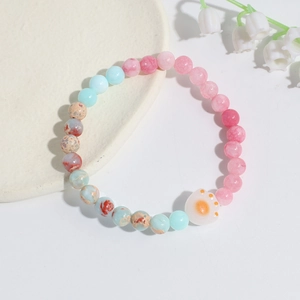 Detail of beaded bracelet with pink crystal, blue stones and a cute white cat paw pendant
