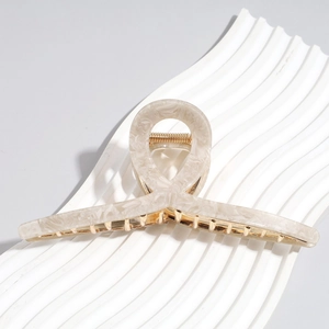 Detail of 13cm oversized beige marble claw clip with sturdy golden metal spring