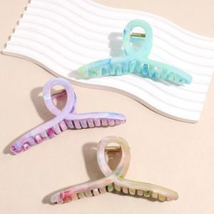 Three-piece set of large marble textured acetate hair claws in blue, purple, and beige