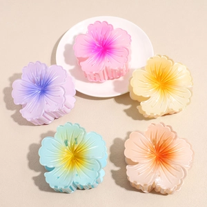 Five matte translucent frangipani flower hair claws in vibrant gradient pastel colors