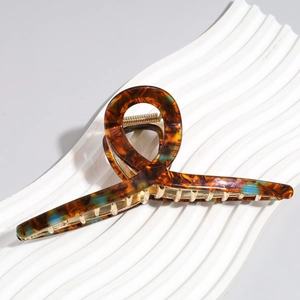 Detail showing 13cm oversized tortoise shell hair claw with blue accents and gold spring