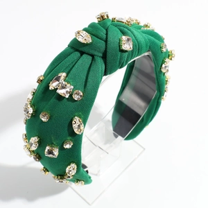 Détail d'un serre-tête noué vert émeraude orné de luxueux strass brillants