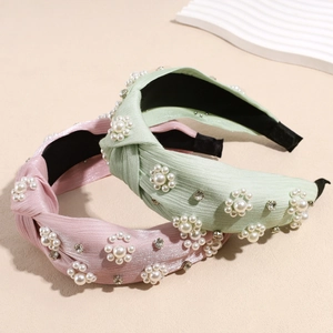Pink and mint green knotted headband with pearl flower decor and silk-like fabric texture