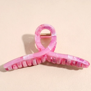 Detailed side view of large pink marble hair claw clip with golden metal spring