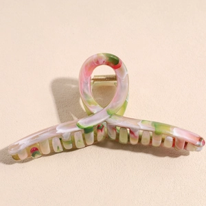 Detail of large marble effect hair claw clip with colorful ink wash texture and gold spring