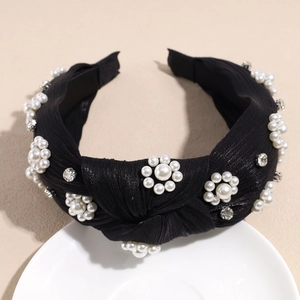 Close-up of a black knotted headband with elegant pearl flower clusters and crystals