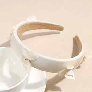 Detail of off-white satin padded headband with 3D fabric flowers and faux pearl centers