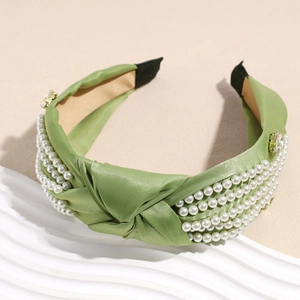 Detail of olive green knotted headband with white pearls and sparkling crystal accents