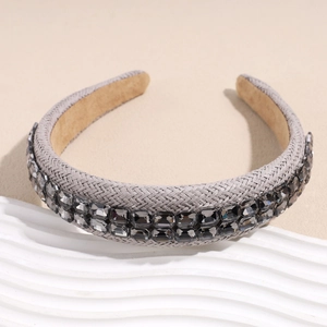 Détail du serre-tête en raphia tressé avec double rangée de strass gris