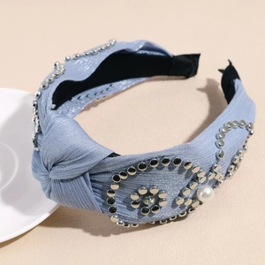 Detail eines blauen Knotenstirnbands mit Silbernieten mit Silbernieten und eleganten Perlenakzenten