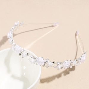 Détails de fleurs de rose blanches et perles sur un serre-tête de mariée délicat