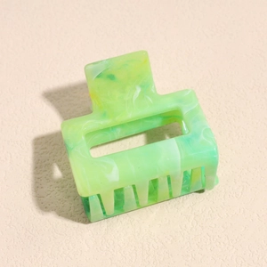 Detail of green marble texture on a rectangular hollow hair claw clip for women