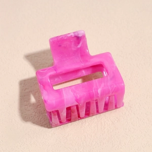 Detail shot of rectangular pink marble pattern hair claw clip with matte frosted finish