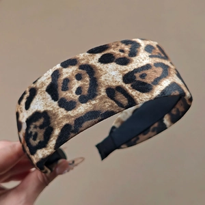 Detail view of wide leopard print velvet headband with soft black inner lining for women