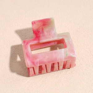 Macro detail of the square resin hair claw clip with pink and green marble pattern