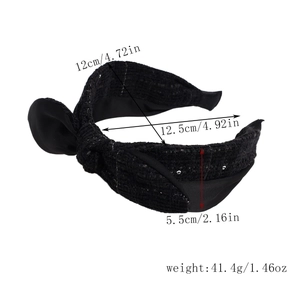 Detaillierte Größenangaben für das schwarze Tweed-Stirnband mit Schleifendekor und Gewicht