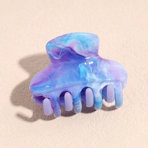 Detail view of a marble pattern hair claw clip with blue and purple gradient resin texture