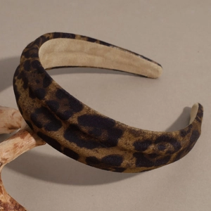 Close-up of leopard print headband texture on a minimalist wooden branch prop