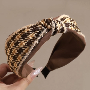 Detail of a wide knot headband with brown houndstooth tweed fabric for autumn style