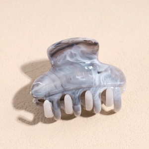 Macro shot of grey marble pattern hair claw clip with polished acetate finish
