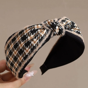 Detailed close-up of a knotted houndstooth headband with cozy yellow plush trim accents