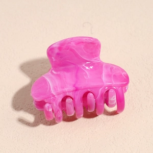 Detailed close-up of pink marble pattern resin hair claw clip with metal spring