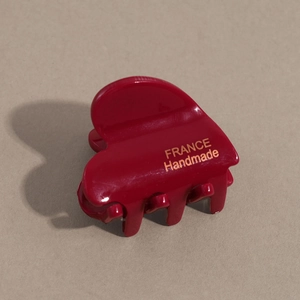 Detail view of burgundy acetate heart hair claw with gold France Handmade lettering