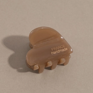 Close-up of amber brown acetate heart hair claw with gold France Handmade lettering
