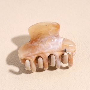 Macro detail of the smooth amber marble texture and spring claw on this plastic hair clip