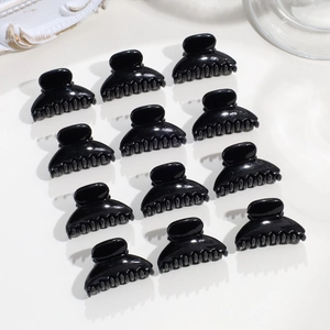 Vista dettagliata di 12 mini mollette per capelli nere a forma di corona per lo styling