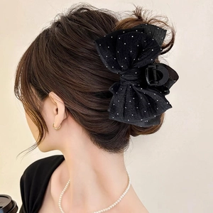 Elegant large black mesh bow hair claw clip with rhinestones worn by a model