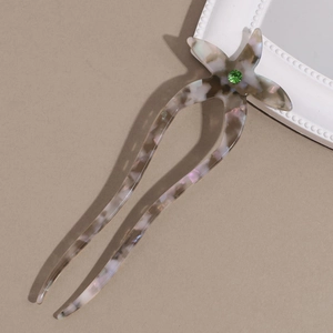 Detail view of acetate starfish hair fork with green rhinestone inlay and ink marble texture