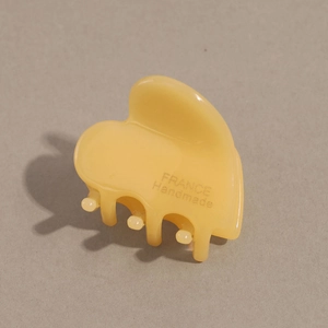 Detailed macro of yellow heart hair claw featuring gold France Handmade logo text