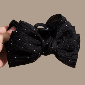 Detail of black mesh bow hair claw clip with sparkling rhinestones and chiffon fabric