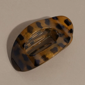 Vue détaillée de la pince à cheveux ovale plate avec motif ambre écaille de tortue