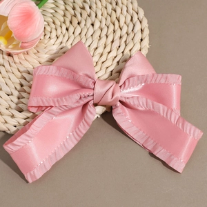 Eleganter rosa Satin-Haarclip mit Schleife und Rüschen auf einer gewebten Matte mit Tulpen