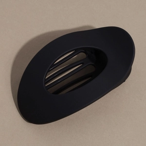 Détail de la pince à cheveux ovale noir mat avec design creux et dents de fixation solides