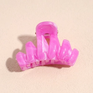 Macro shot of pink marble texture and silver metal spring on the acetate hair claw