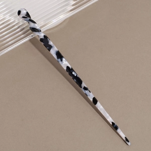 Detail of twisted spiral hair stick featuring elegant black and white marble pattern